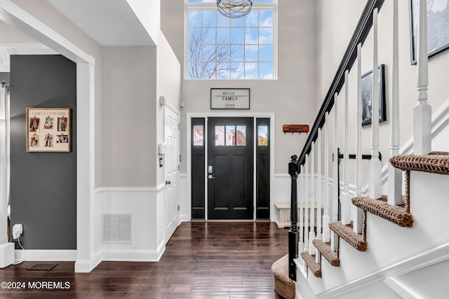 foyer with dark hardwood / wood-style flooring and a towering ceiling