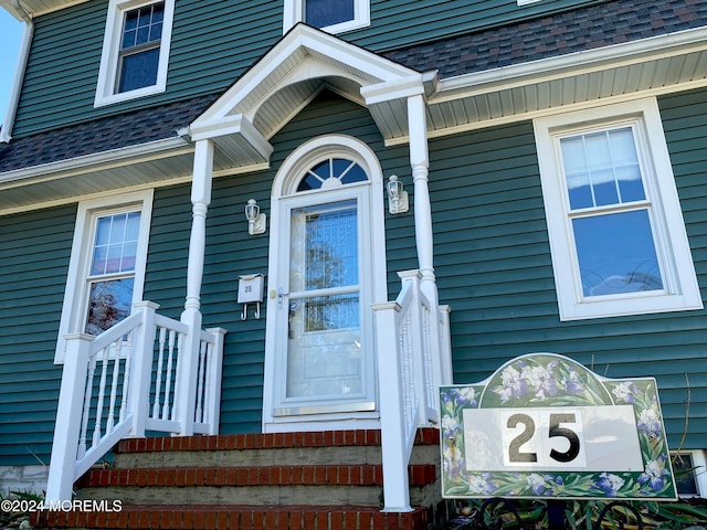 entrance to property with a shingled roof