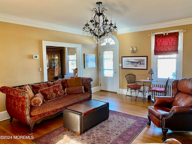 living room with hardwood / wood-style flooring, crown molding, and an inviting chandelier