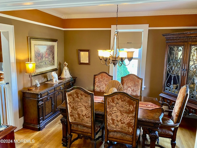 dining room featuring light hardwood / wood-style floors, ornamental molding, and a chandelier