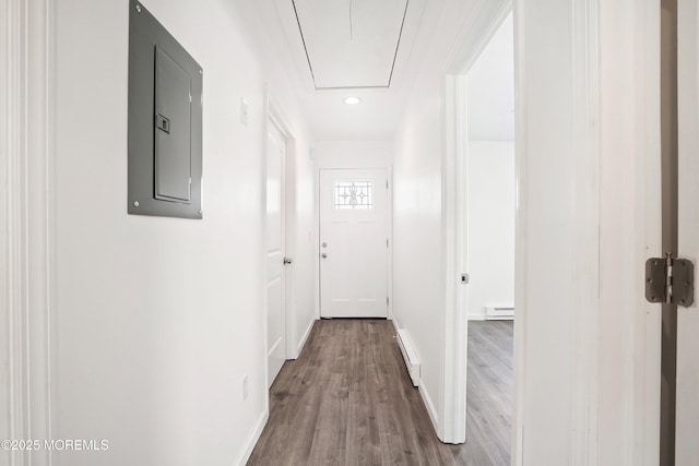 corridor featuring electric panel, a baseboard heating unit, and wood-type flooring