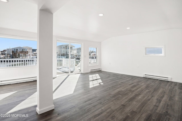 unfurnished living room featuring baseboard heating, dark hardwood / wood-style flooring, and plenty of natural light