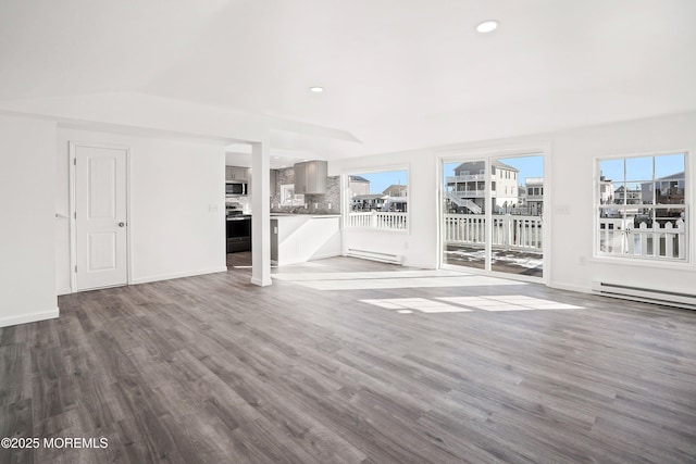 unfurnished living room with a baseboard radiator, plenty of natural light, and wood-type flooring