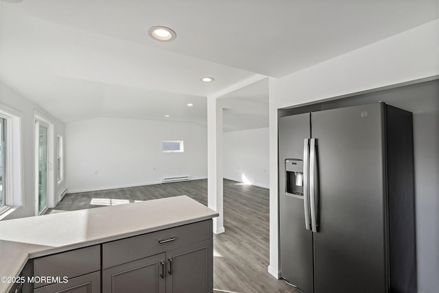 kitchen with vaulted ceiling, dark hardwood / wood-style floors, gray cabinets, stainless steel refrigerator with ice dispenser, and a baseboard radiator