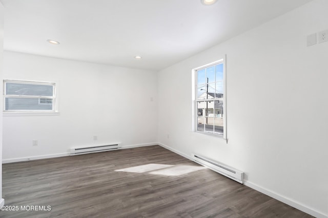 empty room with a baseboard radiator and dark hardwood / wood-style floors