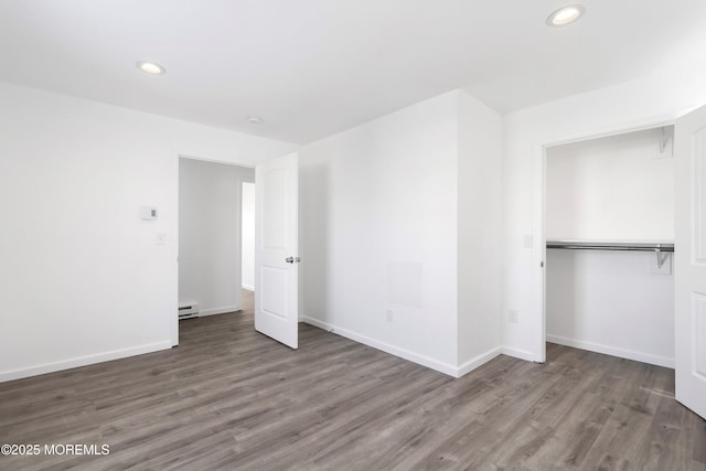 unfurnished bedroom with dark hardwood / wood-style flooring, a closet, and a baseboard radiator