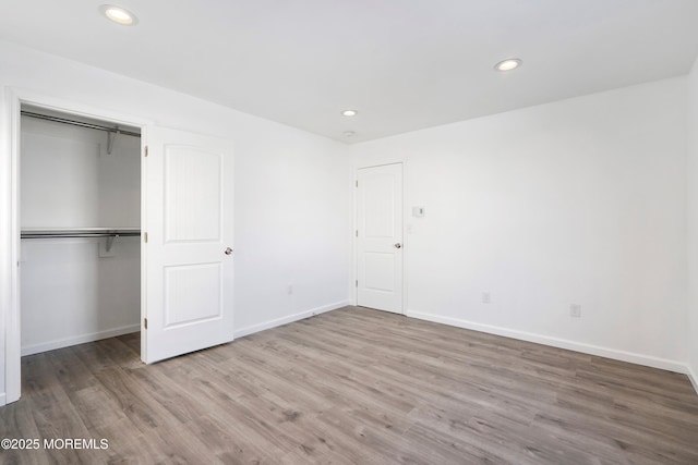 unfurnished bedroom with hardwood / wood-style flooring and a closet