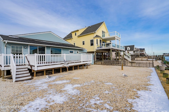 snow covered house featuring a deck