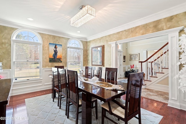 dining room with dark hardwood / wood-style floors, decorative columns, and ornamental molding