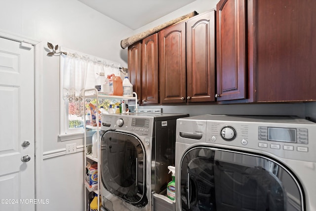 washroom featuring washing machine and dryer and cabinets