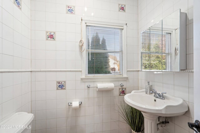 bathroom featuring tasteful backsplash, toilet, and tile walls