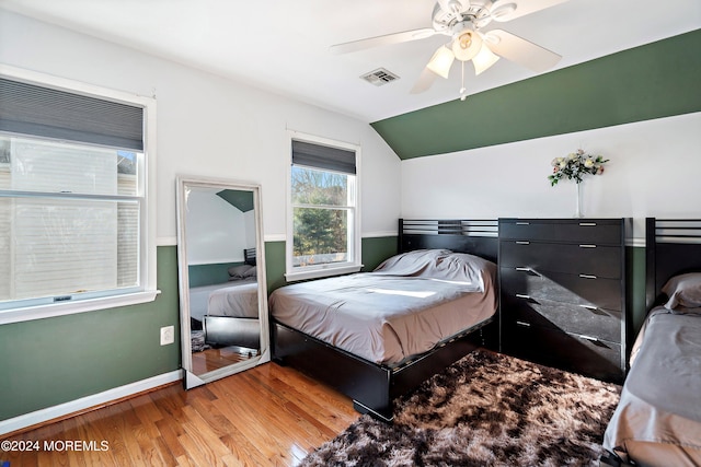 bedroom with ceiling fan, lofted ceiling, and light hardwood / wood-style flooring