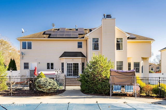 back of house featuring solar panels and a covered pool