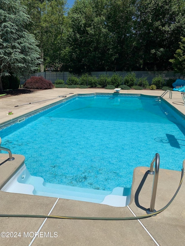 view of pool featuring a diving board and a patio area