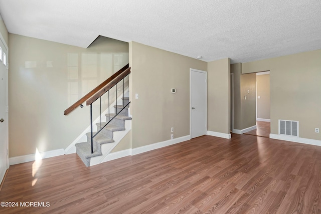 unfurnished living room with a textured ceiling and hardwood / wood-style flooring