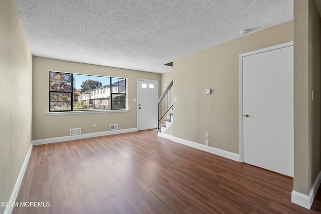 empty room featuring wood-type flooring and a textured ceiling