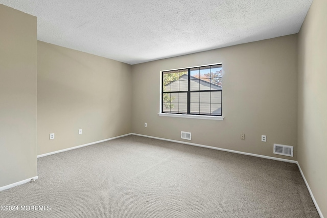 carpeted empty room with a textured ceiling