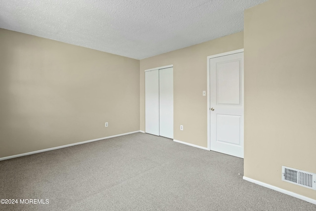 unfurnished bedroom featuring carpet flooring and a textured ceiling