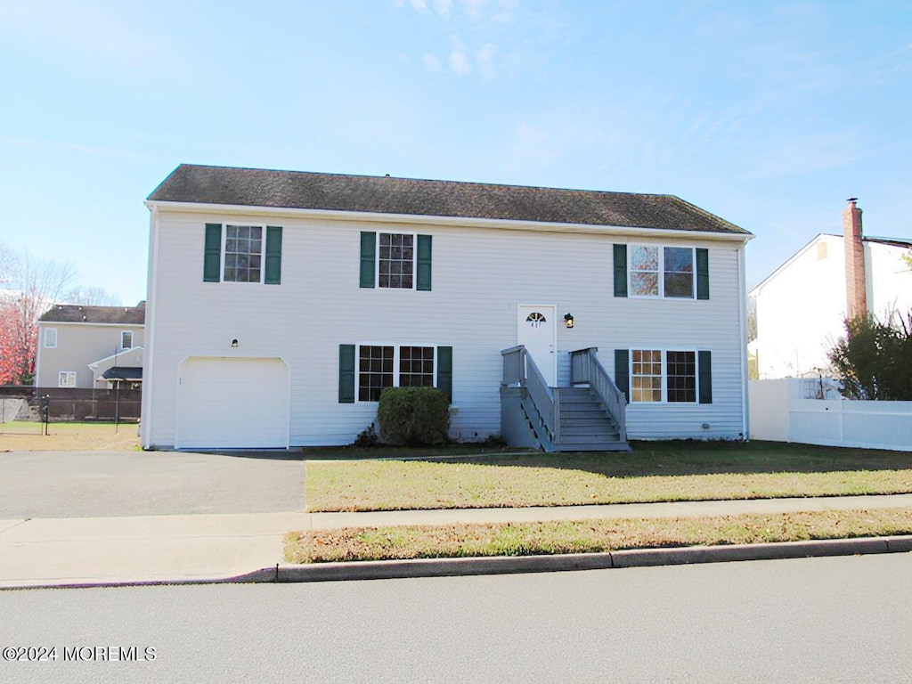 bi-level home with a garage and a front yard