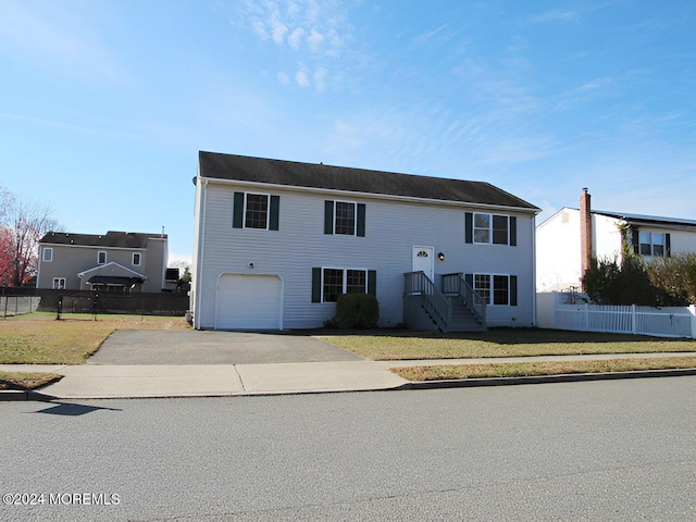 raised ranch with a front lawn and a garage