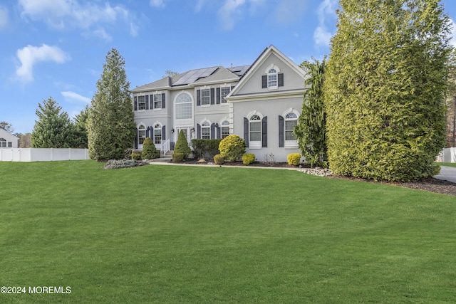 view of front facade featuring a front yard and solar panels