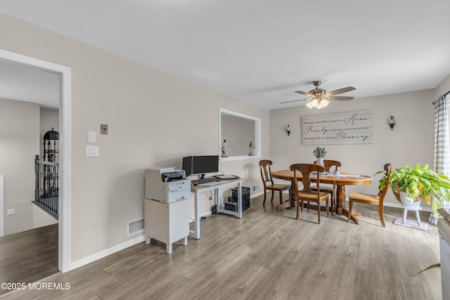 dining area featuring a ceiling fan, wood finished floors, visible vents, and baseboards