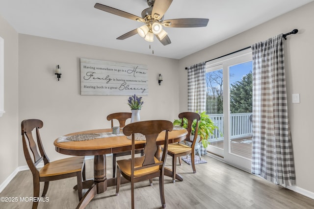 dining space featuring a ceiling fan, light wood-style flooring, and baseboards