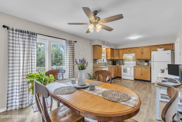 dining space with light wood-style flooring and a ceiling fan