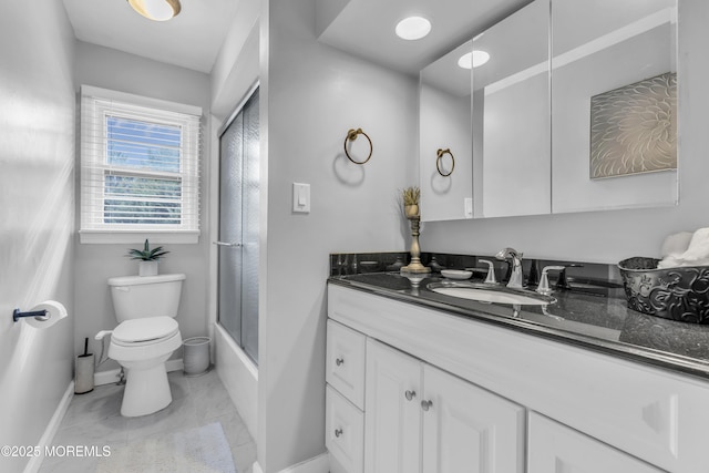 bathroom with baseboards, combined bath / shower with glass door, vanity, and toilet