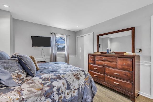 bedroom with light wood-type flooring, a closet, and recessed lighting