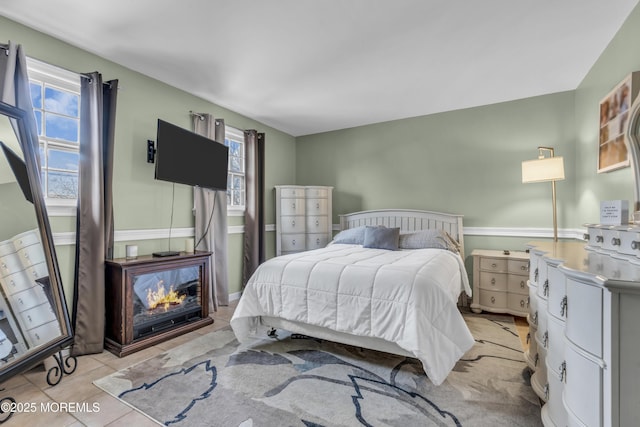 bedroom featuring light tile patterned floors and multiple windows