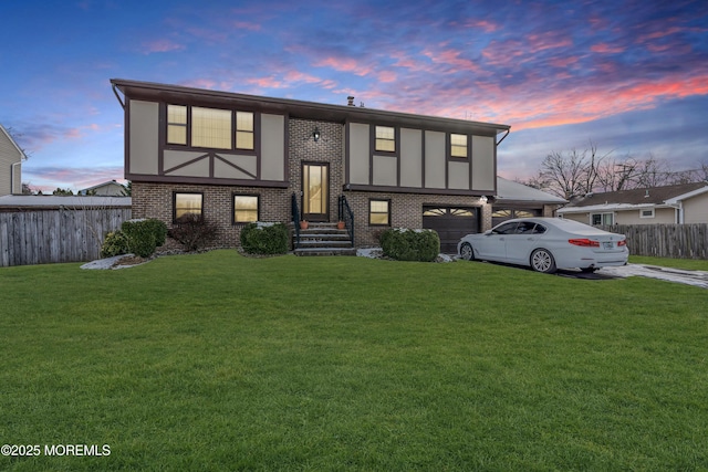 view of front facade with driveway, brick siding, a lawn, and fence