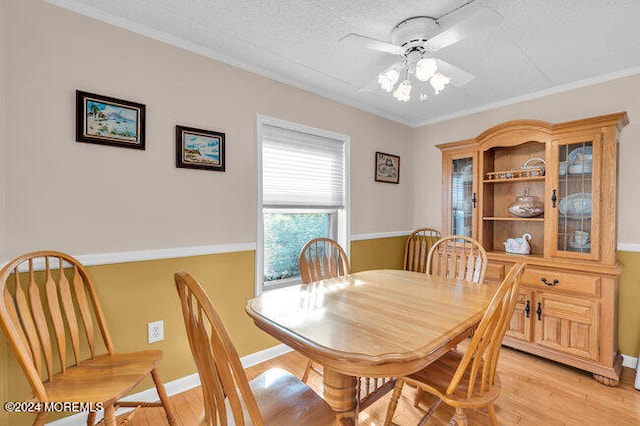 dining space with ceiling fan, light hardwood / wood-style floors, a textured ceiling, and ornamental molding