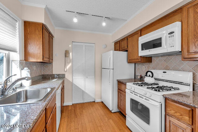 kitchen with white appliances, light stone counters, light hardwood / wood-style flooring, and sink