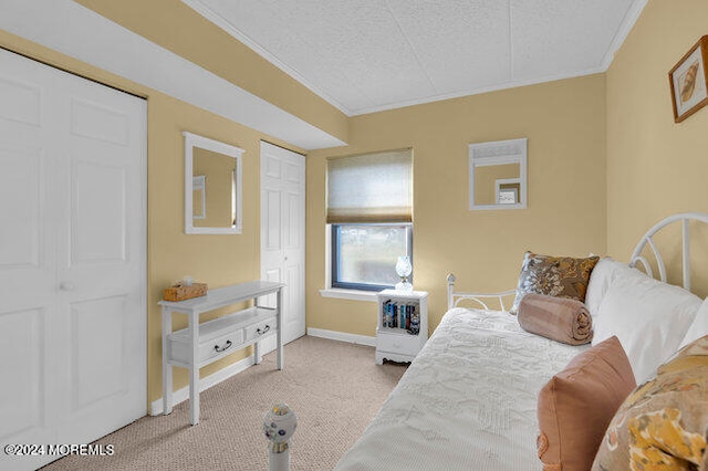 carpeted bedroom with ornamental molding and a textured ceiling