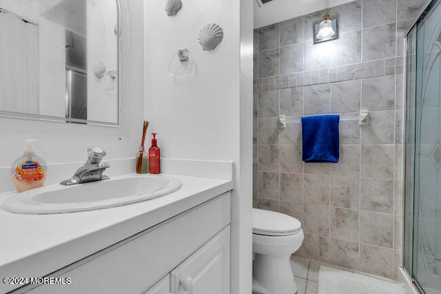 bathroom with tile patterned floors, vanity, toilet, and a shower with shower door