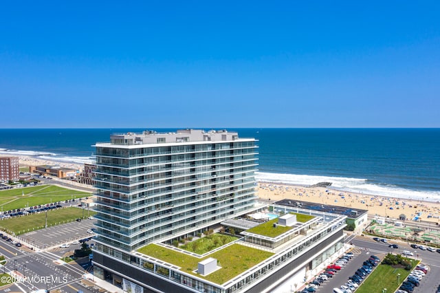 birds eye view of property with a water view and a view of the beach