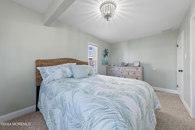 carpeted bedroom with beamed ceiling