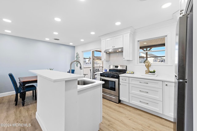 kitchen featuring white cabinetry, a healthy amount of sunlight, light hardwood / wood-style flooring, and stainless steel appliances