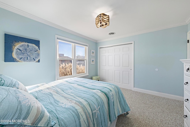 carpeted bedroom with crown molding and a closet