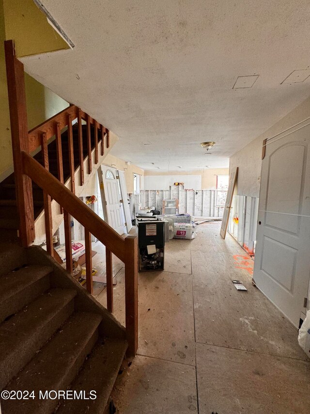 stairway featuring a textured ceiling