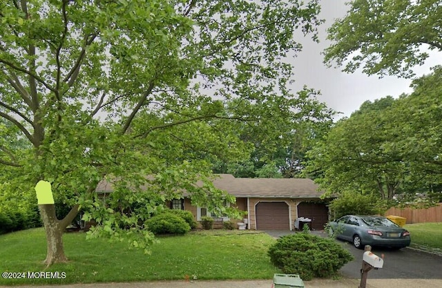 view of front of home with a front yard and a garage