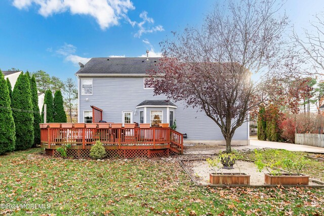 back of property featuring a yard and a wooden deck