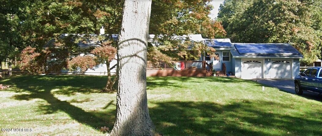 view of yard featuring a garage and a wooden deck