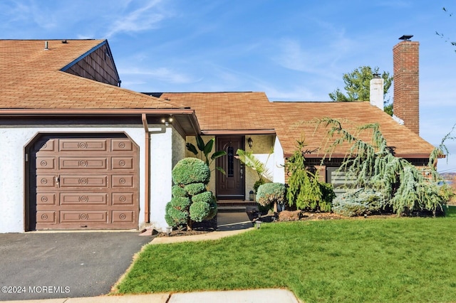 view of front of home with a garage and a front lawn