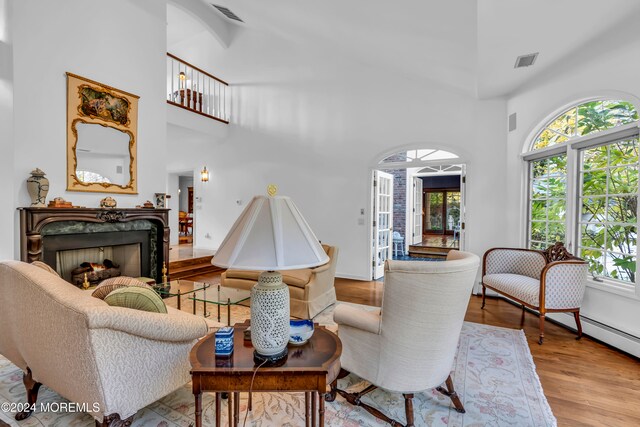 living room featuring light hardwood / wood-style floors and a towering ceiling