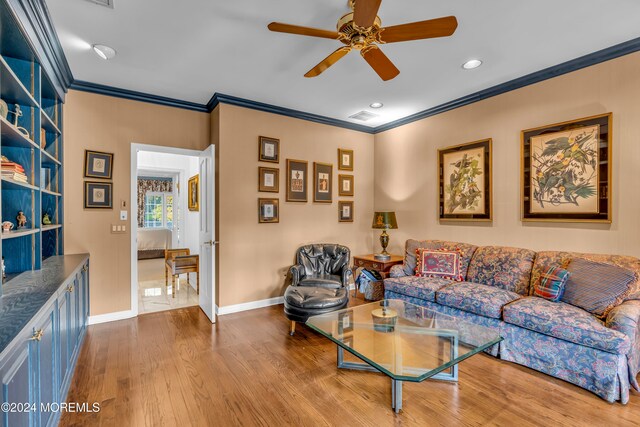 living room with light hardwood / wood-style floors, ceiling fan, and crown molding