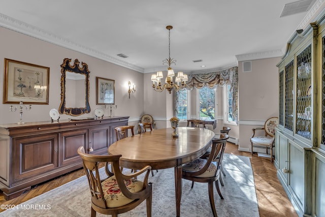 dining space with baseboard heating, crown molding, light hardwood / wood-style flooring, and an inviting chandelier