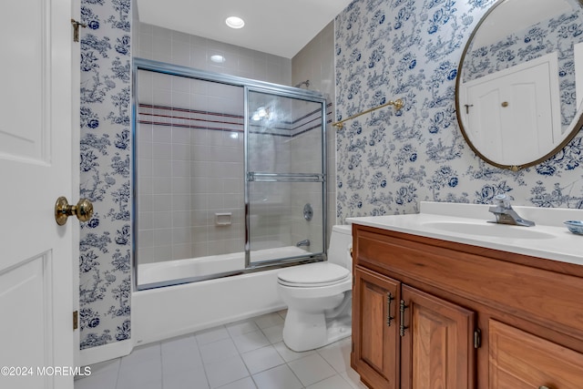 full bathroom with tile patterned floors, vanity, bath / shower combo with glass door, and toilet