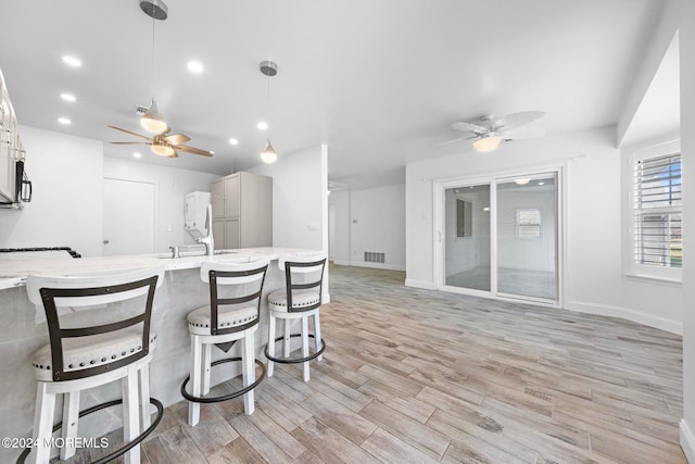 kitchen with sink, pendant lighting, light hardwood / wood-style floors, and white refrigerator